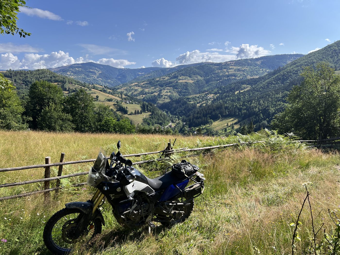 A Yamaha T7 beside a wooden fence above a green Transylvanian valley